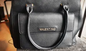Czarna torebka Valentino z tłoczonym logo. Jak rozpoznać oryginalną? Detale i jakość wykonania są kluczowe.