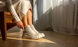 Damskie buty Palladium w beżowo-szarym kolorze na grubej podeszwie, noszone z dzianinową sukienką.
