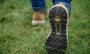 Podeszwa buta trekkingowego na trawie.