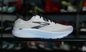 Biały but biegowy Brooks Ghost z niebieską podeszwą środkową z pianki **phylon**, idealny do komfortowych treningów.