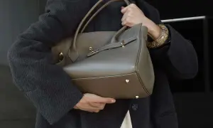 Elegancka, szara torebka na ramię z uchwytami i złotymi elementami. Klasyczne, jakie torebki są teraz modne, to te o prostych, ponadczasowych formach.