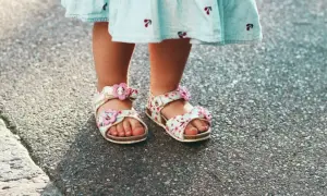 Dziecko w sandałkach z kwiatkami. Chcesz wiedzieć, jak zmierzyć stopę dziecku? To proste, wystarczy zmierzyć długość stopy od pięty do najdłuższego palca.