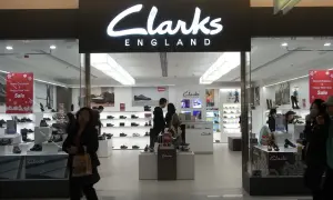 Sklep Clarks, znanej firmy obuwniczej z Anglii, oferuje szeroki wybór butów. Widać tu ekspozycję obuwia i klientów.
