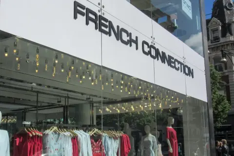 Sklep French Connection, znana marka odzieżowa, prezentuje stylowe sukienki i bluzki w witrynie.
