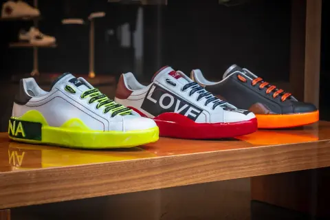 Trzy designerskie sneakersy co to za modele! Białe z neonową podeszwą, czerwone z napisem LOVE i czarne z pomarańczowymi sznurówkami.