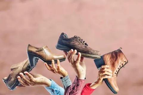 Różne buty trzymane w dłoniach, jakby na pokaz. Czy to symboliczne odniesienie do przesądów o butach i ich znaczeniu?
