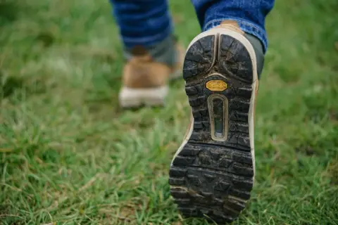 Podeszwa buta trekkingowego na trawie.
