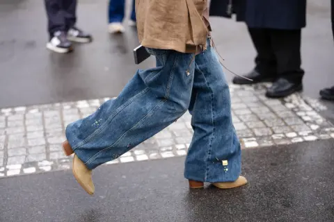 Modne, szerokie dzwony i zamszowe botki na obcasie. Takie buty są teraz modne, idealne do stylizacji z jeansu.