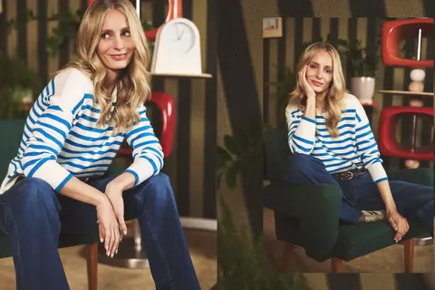 Blondynka w granatowych jeansach i pasiastym swetrze. Inspiracja, co ubrać do jeansów, by wyglądać stylowo i swobodnie.