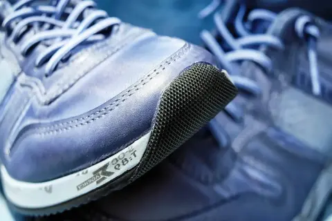 Niebieskie buty sportowe z siateczkowanym noskiem. Logo firmy Rieker widoczne na podeszwie.