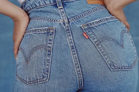 Dopasowane jeansy Levi's, rozmiar w25, z charakterystycznymi kieszeniami i czerwonym logo.