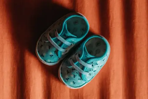 Turkusowe buciki dla chłopca z delikatnym wzorem kwiatowym. Idealne jako pierwsze buty do alby.