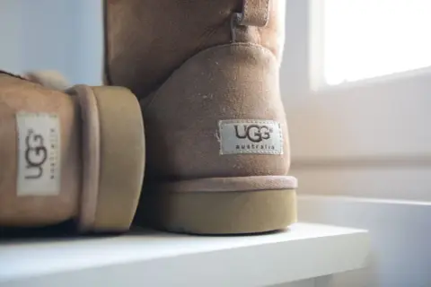 Ciepłe, brązowe buty UGG, idealne na zimowe dni. Miękkie i wygodne, zapewniają komfort.
