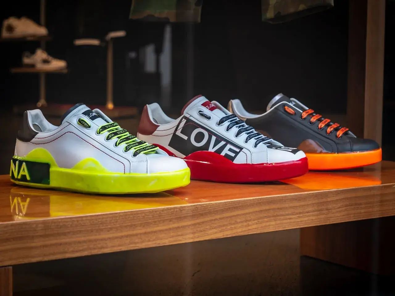 Trzy designerskie sneakersy co to za modele! Białe z neonową podeszwą, czerwone z napisem LOVE i czarne z pomarańczowymi sznurówkami.