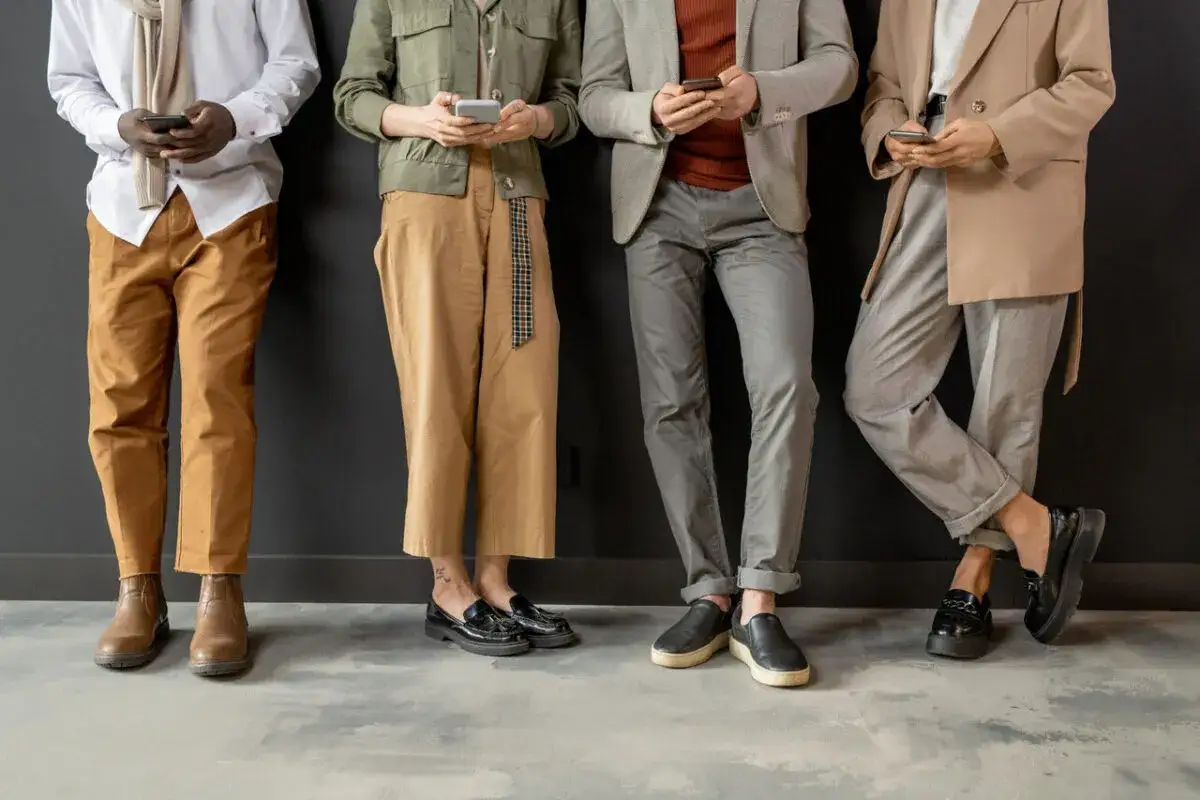 Różne rodzaje dress code: od casual po smart casual, prezentowane przez cztery osoby stojące przy czarnej ścianie.