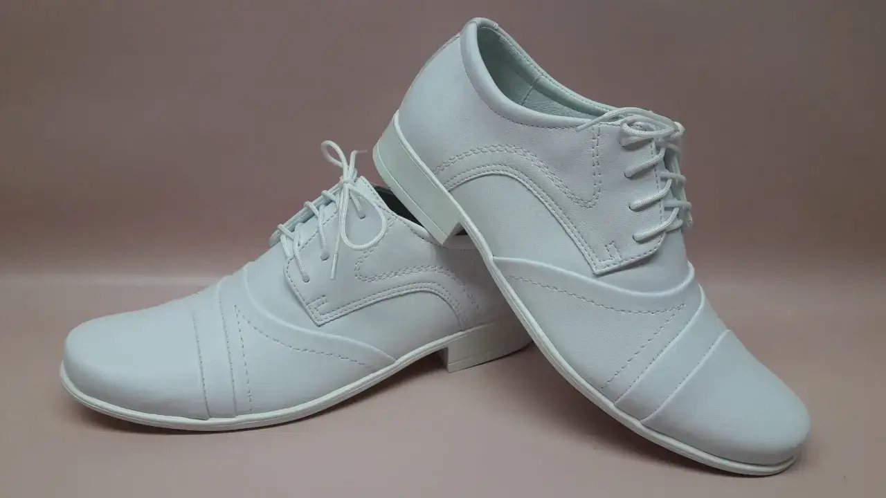 Białe, eleganckie buty sznurowane, idealne jako jakie buty do alby dla chłopca na uroczystość.