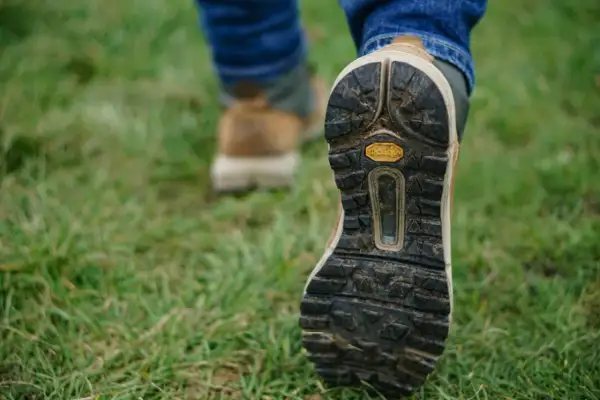 Podeszwa buta trekkingowego na trawie.